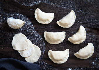 Fototapeta na wymiar Raw dumpling with potatoes. Preparation dumplings on a black background