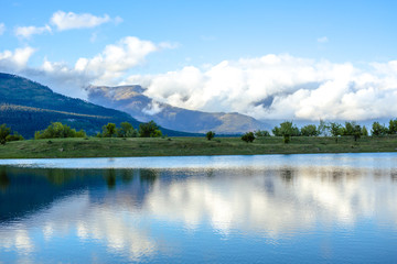 Mountain forest lake reflection, spring and travel time.