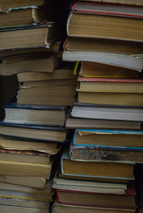 Lots of old books stacked by the wall