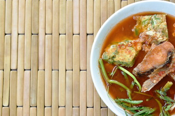 fried fish and egg stuffed climbing wattle in spicy sour soup on bowl