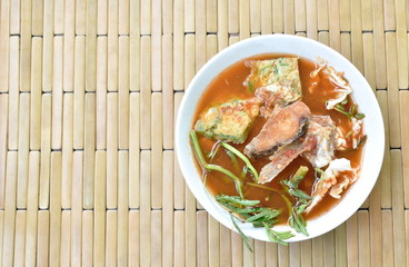 fried fish and egg stuffed climbing wattle in spicy sour soup on bowl