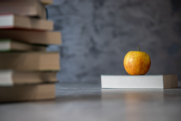 Jabłko na książce na betonowym tle
