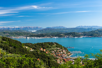 Fototapeta na wymiar Striking view over the La Spezia Gulf and the Gulf of Poets (Golfo dei Poeti),on the Liguria's coast, Italy, with the silhouettes of the snow covered Italian Alps in the background