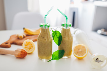 Bottles with spinach and banana smoothie with ingredients. Healthy detox diet
