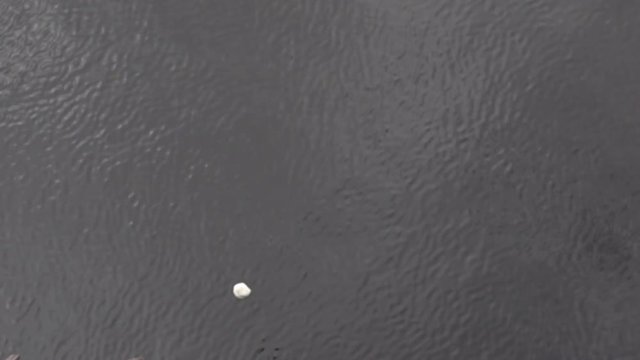 A white throw stone flies from above into the water. A strong splash shows the hydrodynamics of a solid in a liquid medium. Fall into the water with a splash. Super slow motion 1000 fps