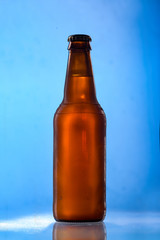Beer bottle with white belgian ale on blue background