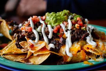 Beef and cheese corn nachos served on a big plate ready to eat