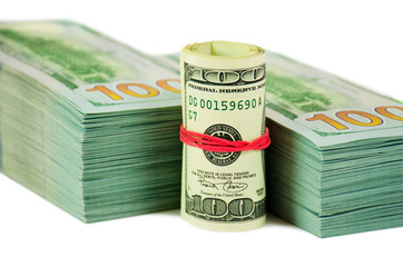A stack of money with a roll front of it isolated in white background