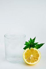 Glass with cold water, lemon and mint. Cool water on a white background