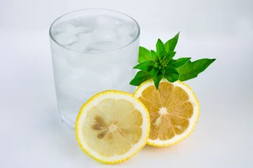 Foto op Plexiglas Glas met koud water, citroen en munt. Koel water op een witte achtergrond © Нафиса Прокофьева
