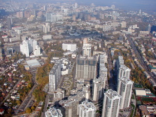 Panorama of the skyscrapers of the residential areas of the Ukrainian capital, surrounded by yellowing of autumn trees, which opens from the window of the plane.