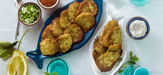 banner of fish patties served on the table with red caviar, green onions and sour cream. fish homemade dish