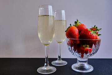 First flavored delicious sweet strawberries with two glasses with white wine 