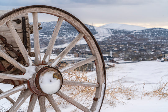 Wooden wheel with rusty metal of an old fashioned cart viewed in winter