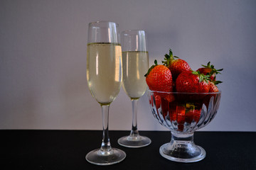 First flavored delicious sweet strawberries with two glasses with white wine 