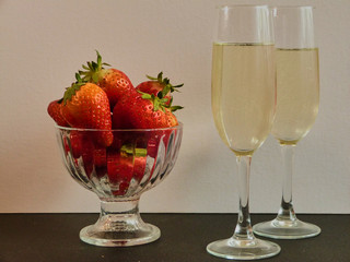 First flavored delicious sweet strawberries with two glasses with white wine 