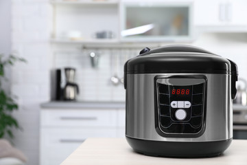 Modern multi cooker on table in kitchen. Space for text