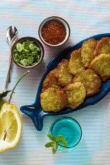 fish patties served on the table with red caviar, green onions and sour cream. fish homemade dish