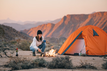 hiker camping in a desert wilderness by a campfire