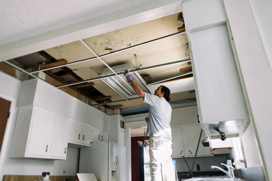 Kitchen: Man Removing Support Struts For Drop Ceiling
