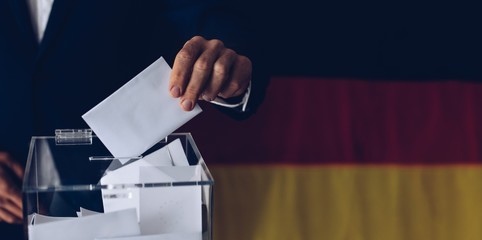 Elections in Germany. Man throwing his vote into the ballot box.