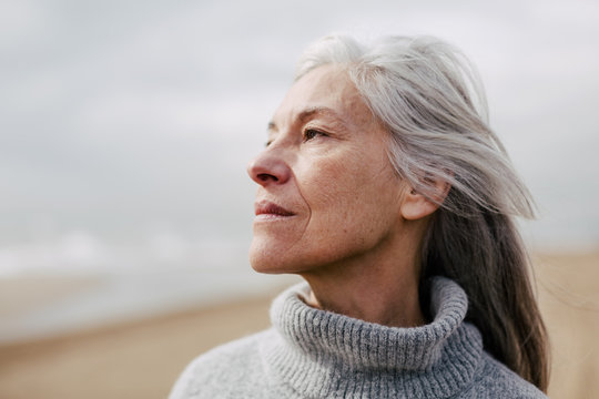 Senior woman enjoying on the beach in winter.