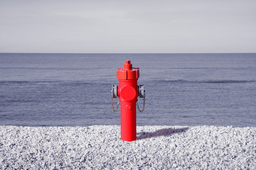 An improbable hydrant at the seaside. Plenty of water concept image