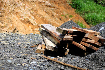 Newly cut and sawed tropical wooden planks on a pile on the side of a road