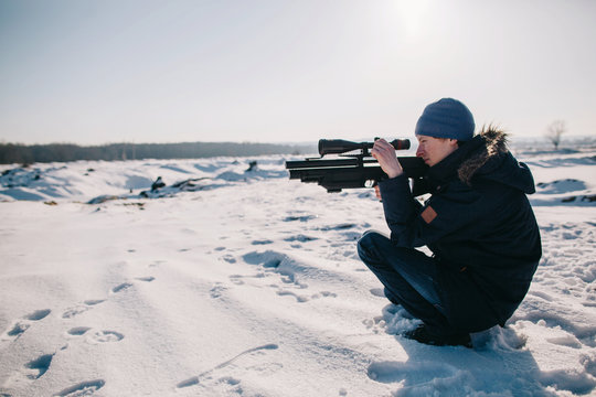 Side view portrait of man aiming with rifle