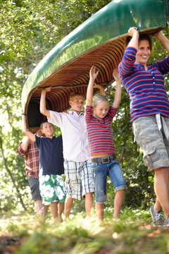 Family carrying a canoe for an outdoor adventure