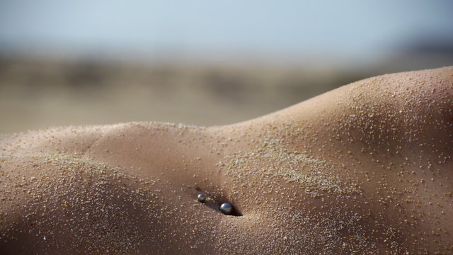 Ombligo de mujer en la playa