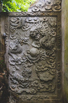 An ornate dragon carving at a temple in the jungle