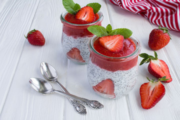 Pudding with chia and strawberry on the white wooden background
