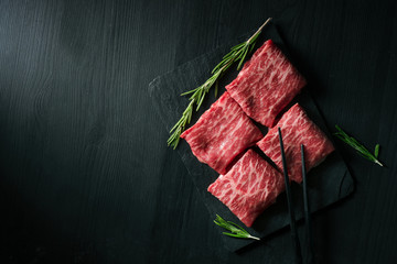 Sliced wagyu marbled beef for yakiniku on plate on black background, Premium Japanese meat, top...