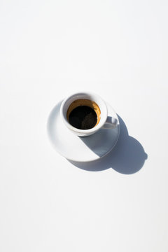 white cup of espresso on white background with copyspace