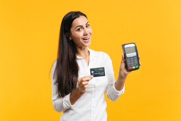 Cheerful young woman holding wireless modern bank payment terminal to process and acquire credit...