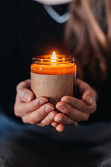 Woman Holding Lit Candle in Hands
