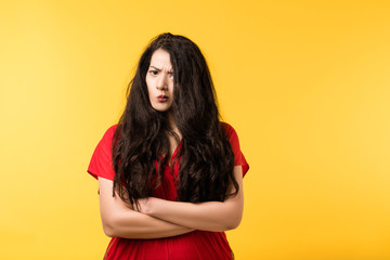 Portrait of suspicious emotional brunette girl with arms folded, concerned, mistrustful facial expression. Copy space.