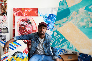 Portrait of proud artist with artwork at the studio.