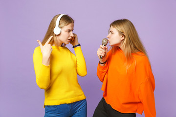 Two concerned blonde twins sisters girls in vivid clothes listen