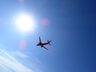 plane flying high in the sky towards the sun