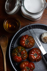 TOMATOES IN METAL TRAY WITH KITCHEN HOLDER, OLIVE OIL, SALT AND WOODEN SPOON