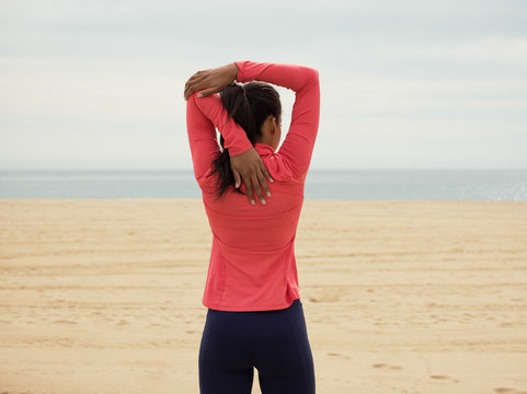 Anonymous woman warming up on beach