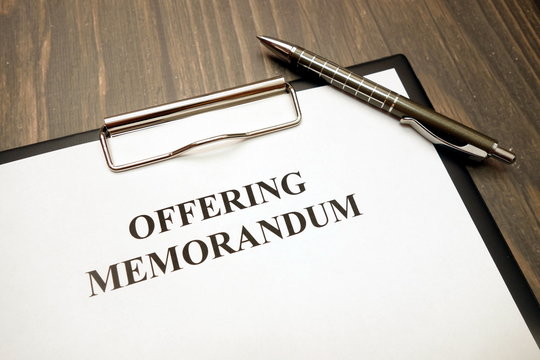 Offering Memorandum Document With Pen On Desk