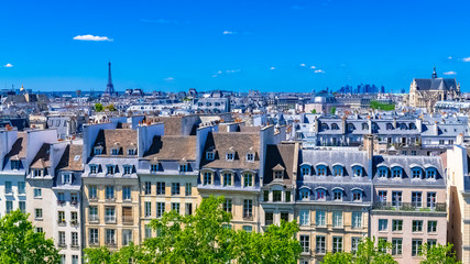 Fototapeta na wymiar Paris, typical roofs in the Marais, aerial view with the Eiffel Tower, the Saint-Eustache church and the Defense in background