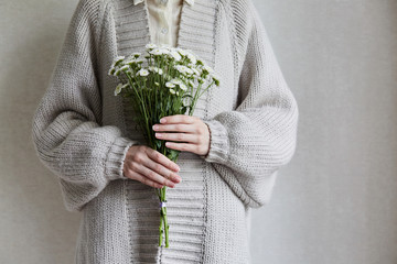 photo of young woman holding white flowers with green stem in her hands - 268192195