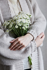 photo of young woman holding white flowers with green stem in her hands - 268192379