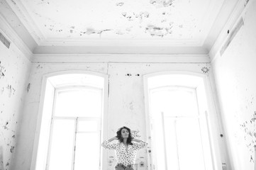 Young woman in a blouse in an abandoned room