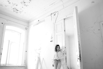 Young woman in a blouse in an abandoned room
