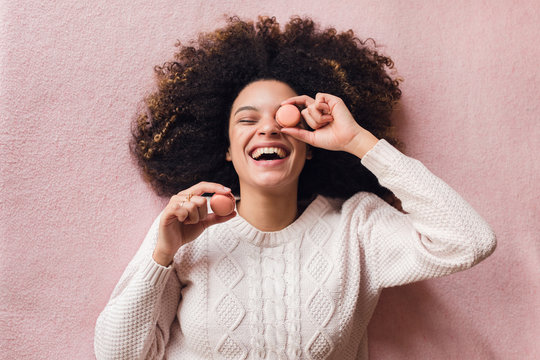 Young afro woman with macaron sweets
